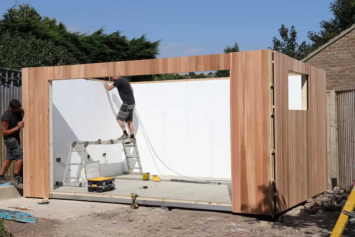 Self build garden room being installed & built by 2 men 